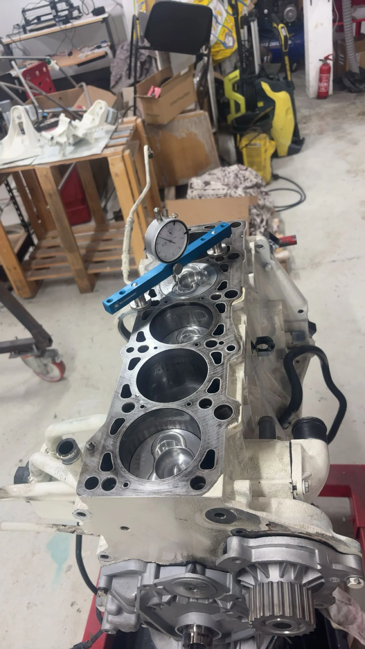Bloc moteur ouvert avec cylindres visibles et comparateur de mesure dans l’atelier