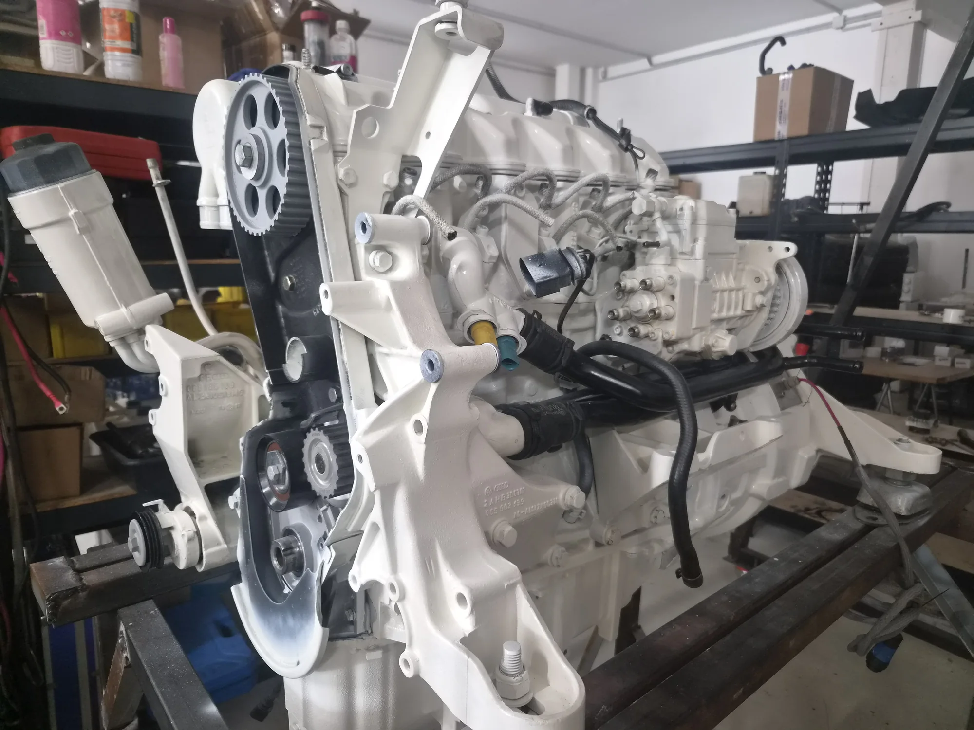 Moteur marin remonté photographié sur son support dans l’atelier
